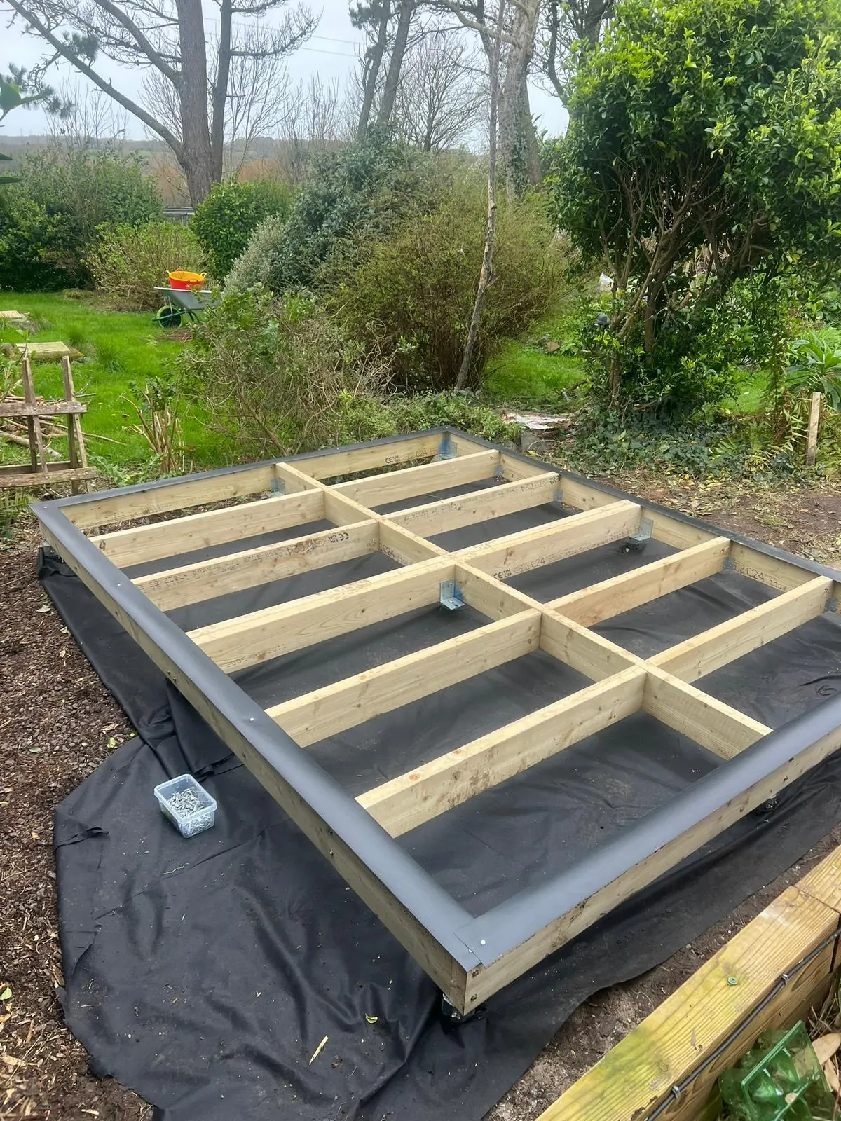 Compact treated timber base prepared on a weed-control membrane