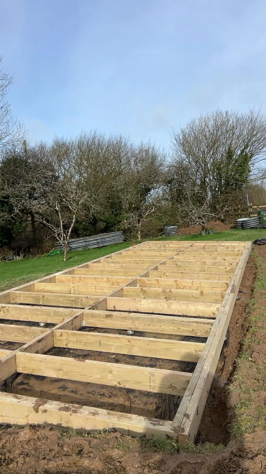 Long treated timber foundation frame installed in a rural Cornwall garden