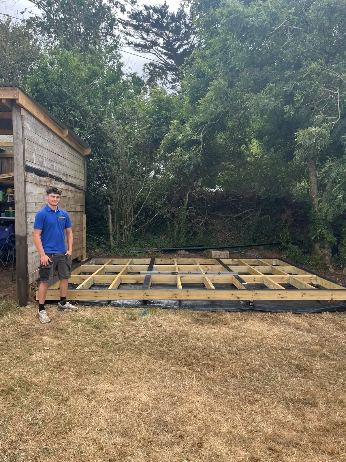 Oliver, founder of Base & Build, standing beside a completed timber ground screw base in Cornwall
