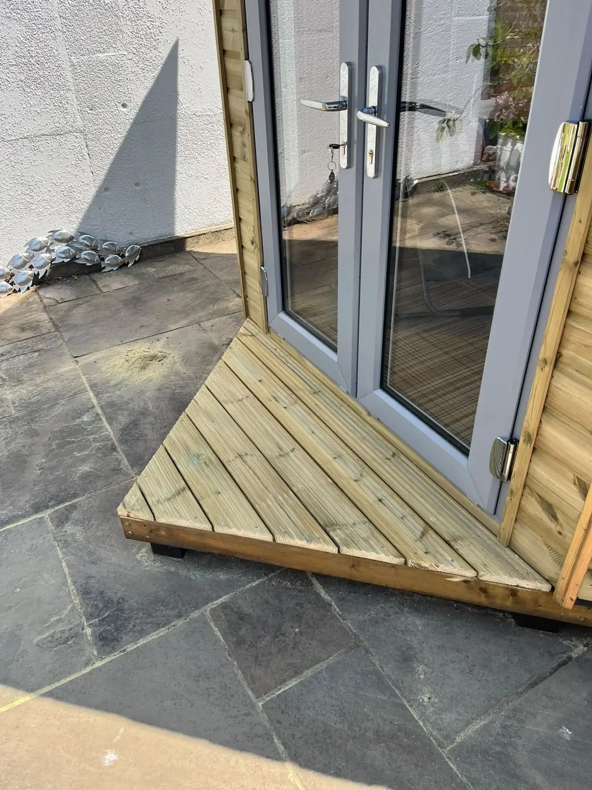 Neatly finished timber entrance step on a completed garden building