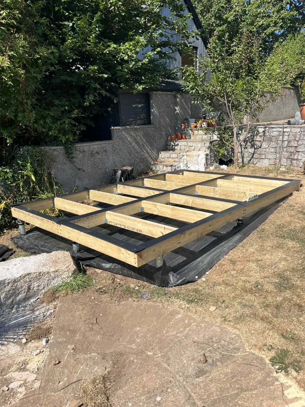 Ground screw foundation supporting a treated timber garden building base