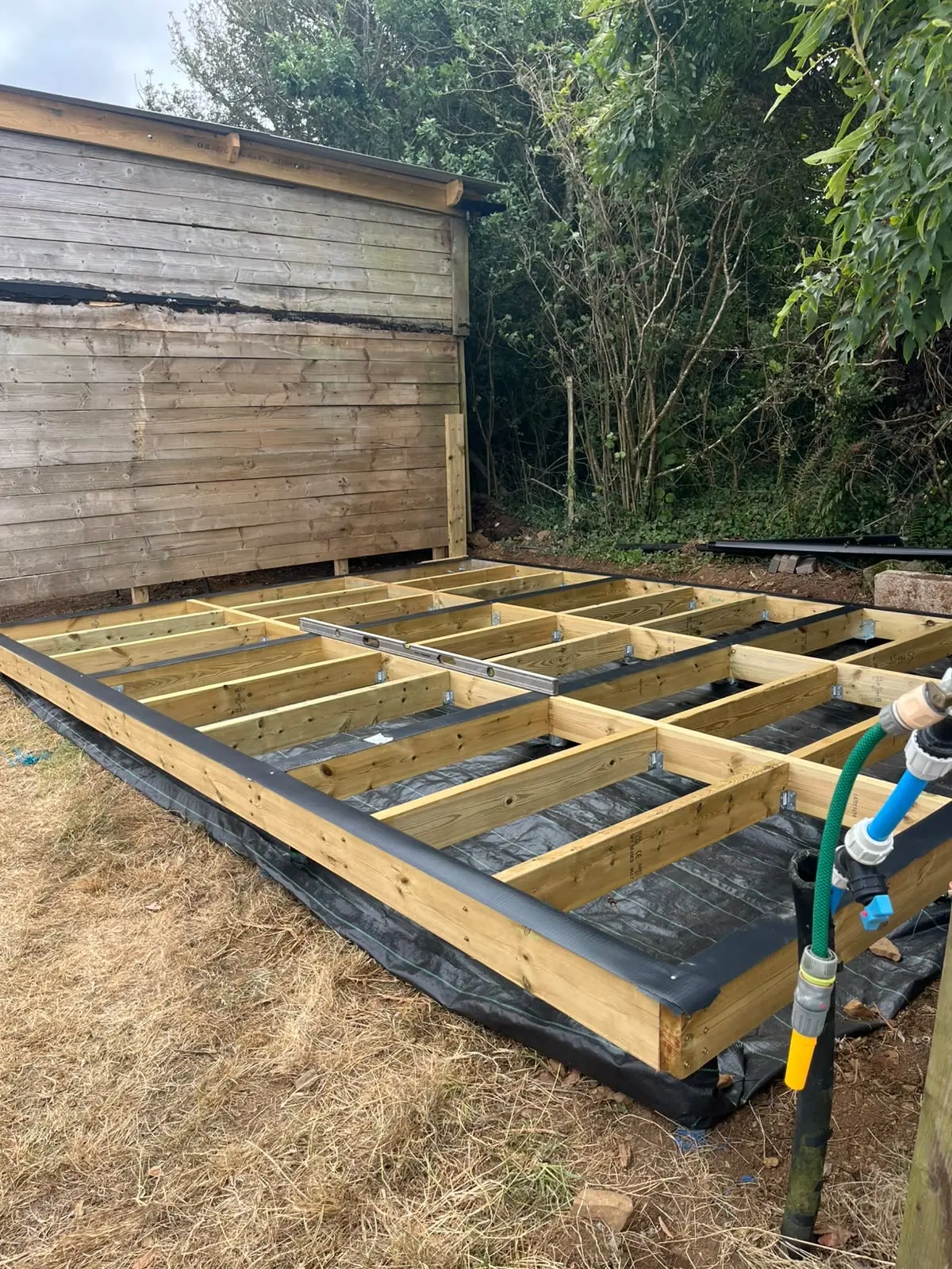 Ground screw and timber base checked level before building installation